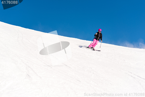 Image of Female skier in fresh powder snow and blue sky