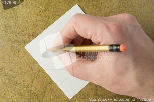 Image of Hand with pencil and piece of sheet
