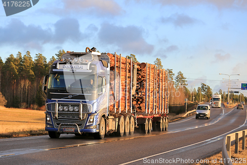 Image of Blue Volvo FH16 Wood Transport Truck on Highway in Winter 