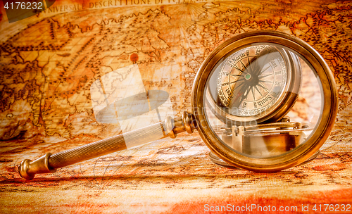 Image of Vintage magnifying glass lies on an ancient world map