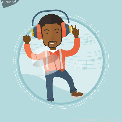 Image of Man listening to music in headphones and dancing.
