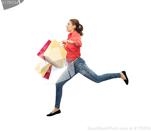 Image of smiling young woman with shopping bags jumping