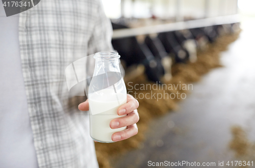 Image of close up of man or farmer with milk on dairy farm