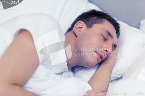 Image of handsome man sleeping in bed