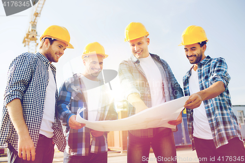 Image of group of builders with tablet pc and blueprint