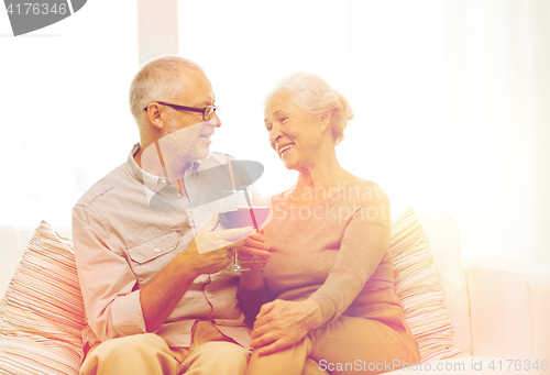 Image of happy senior couple with glasses of red wine
