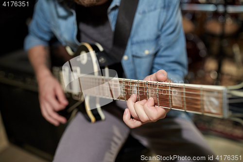 Image of man playing guitar at studio rehearsal