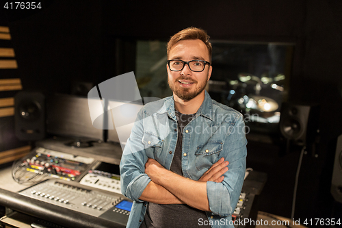 Image of man at mixing console in music recording studio