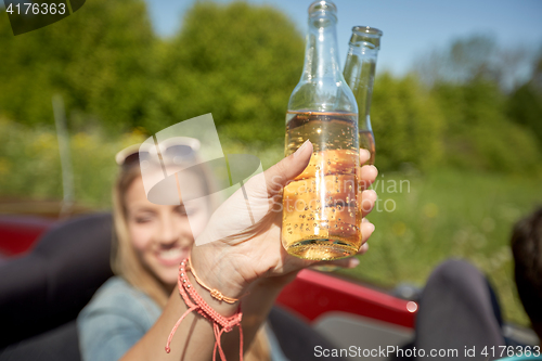 Image of happy young women with drinks in convertible car