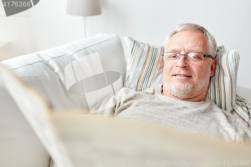 Image of close up of senior man reading newspaper at home