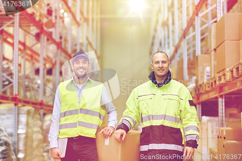 Image of men in uniform with boxes at warehouse