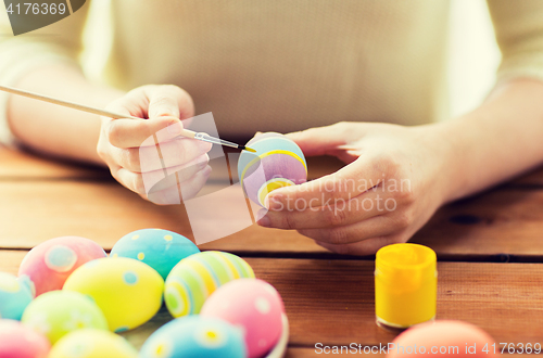 Image of close up of woman hands coloring easter eggs