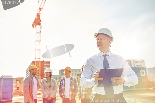 Image of happy builders and architect at construction site