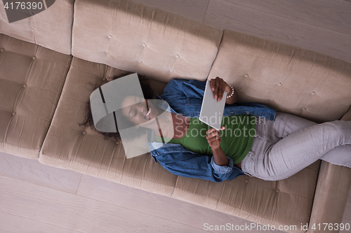 Image of african american woman at home with digital tablet top view