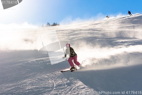 Image of Female skier in fresh powder snow and sunlight