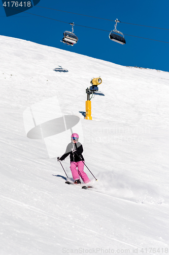 Image of Female skier in fresh powder snow and blue sky