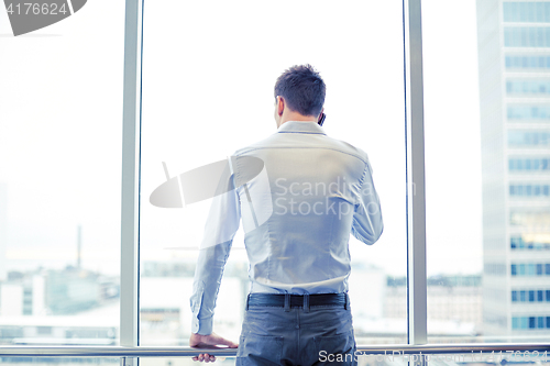 Image of businessman calling on smartphone in office