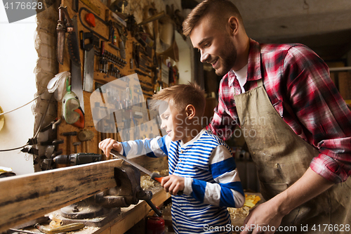 Image of father and son with rasp working at workshop