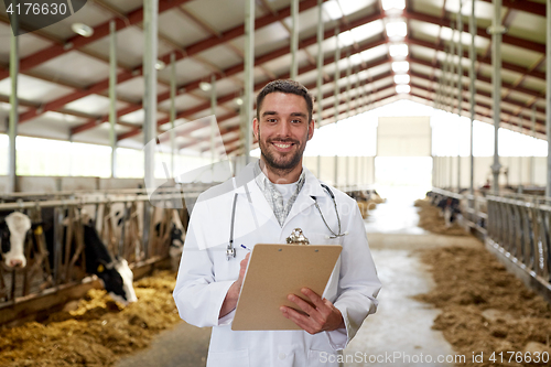 Image of veterinarian with cows in cowshed on dairy farm