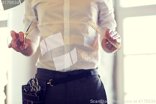 Image of close up of male stylist with scissors at salon