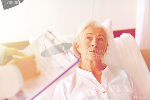 Image of doctor visiting senior woman patient at hospital