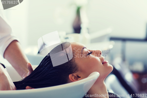 Image of happy young woman at hair salon