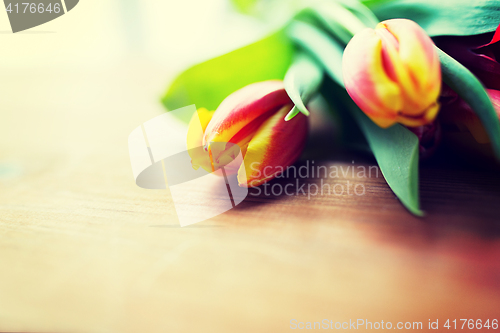 Image of close up of tulip flowers on wooden table