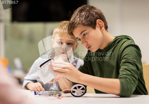 Image of happy children building robots at robotics school