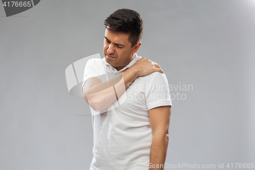 Image of unhappy man suffering from pain in shoulder