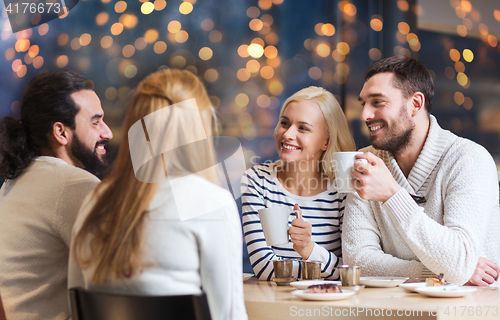 Image of happy friends drinking tea at cafe