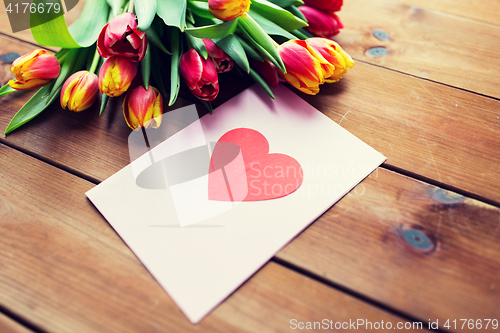 Image of close up of flowers and greeting card with heart