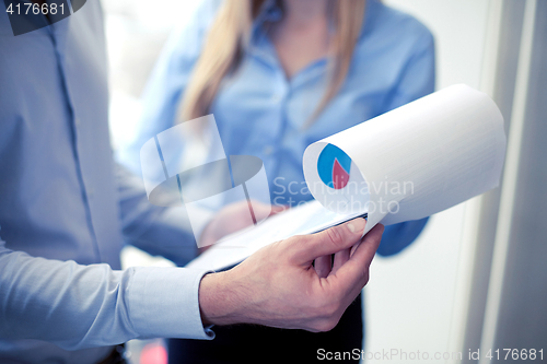 Image of close up of business team looking at clipboard