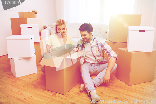 Image of smiling couple with big boxes moving to new home