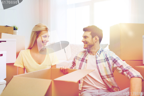 Image of smiling couple with many boxes moving to new home