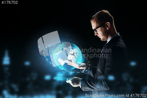 Image of businessman with tablet pc and earth hologram