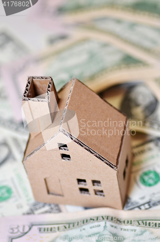 Image of Miniature paper made house stand on  money