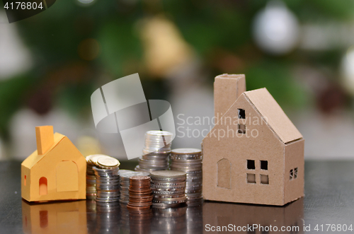 Image of Paper house and stacks of coins standing
