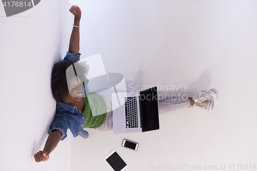 Image of african american woman sitting on floor with laptop top view