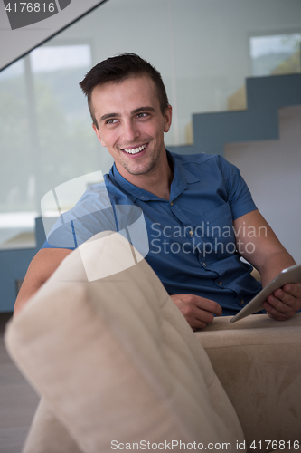 Image of young man using a tablet at home