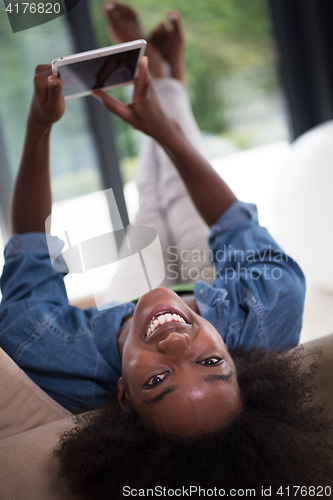 Image of african american woman at home with digital tablet