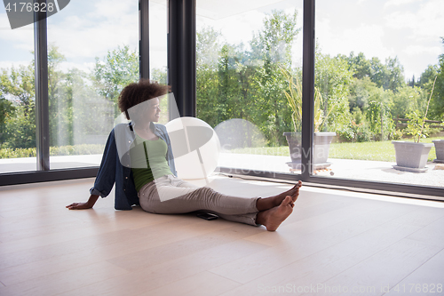 Image of african american  woman  sitting near window