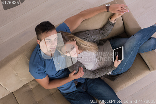 Image of youg couple in living room with tablet top view