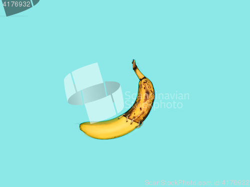 Image of Single banana against blue background