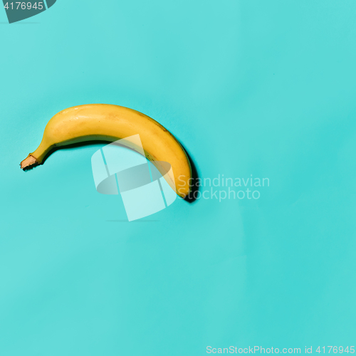 Image of Single banana against blue background