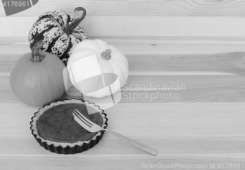 Image of Three pumpkins with small pumpkin pie and fork