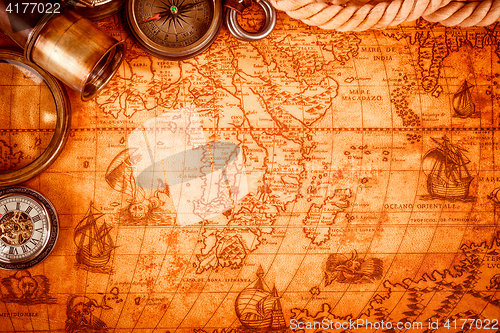 Image of Vintage magnifying glass lies on an ancient world map