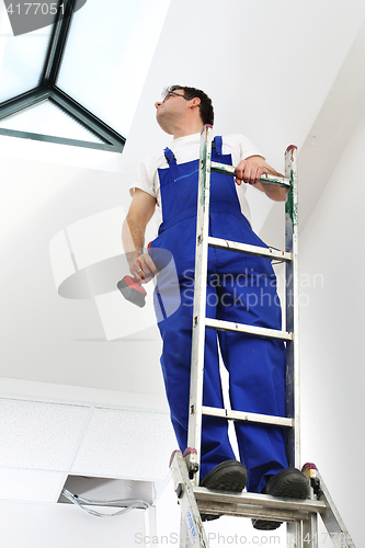 Image of Skylights, professional company assembler. A man on a ladder.