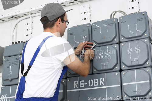 Image of Electrician repairs dashboard.