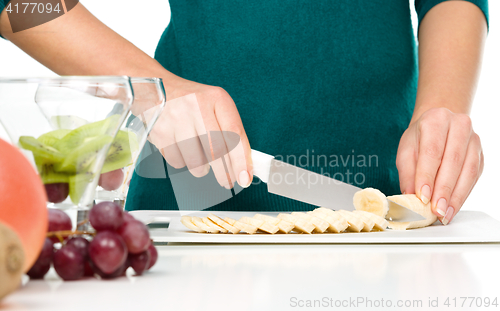 Image of Cook is chopping banana for fruit dessert