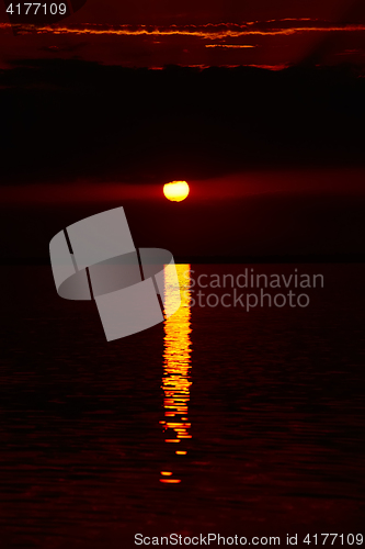 Image of Sunrise in the sea with soft wave and cloudy